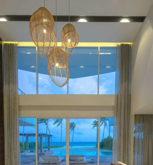 Elegant modern living room with ocean view, featuring luxury decor and lighting.