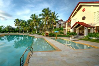 Sunny tropical resort with pool and palm trees, ideal for vacation escape.