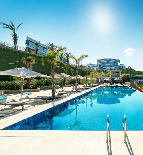 A luxurious seaside resort in Bodrum, Turkey, featuring a stunning infinity pool under sunny skies.