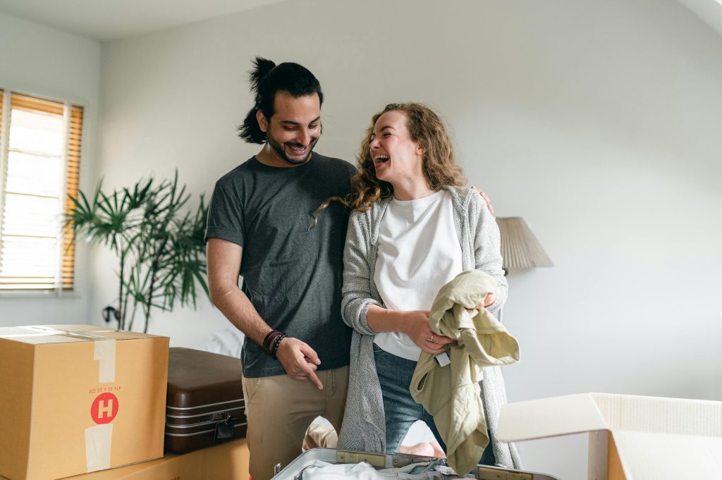 A joyful couple unpacking boxes in their new home, celebrating a fresh start.